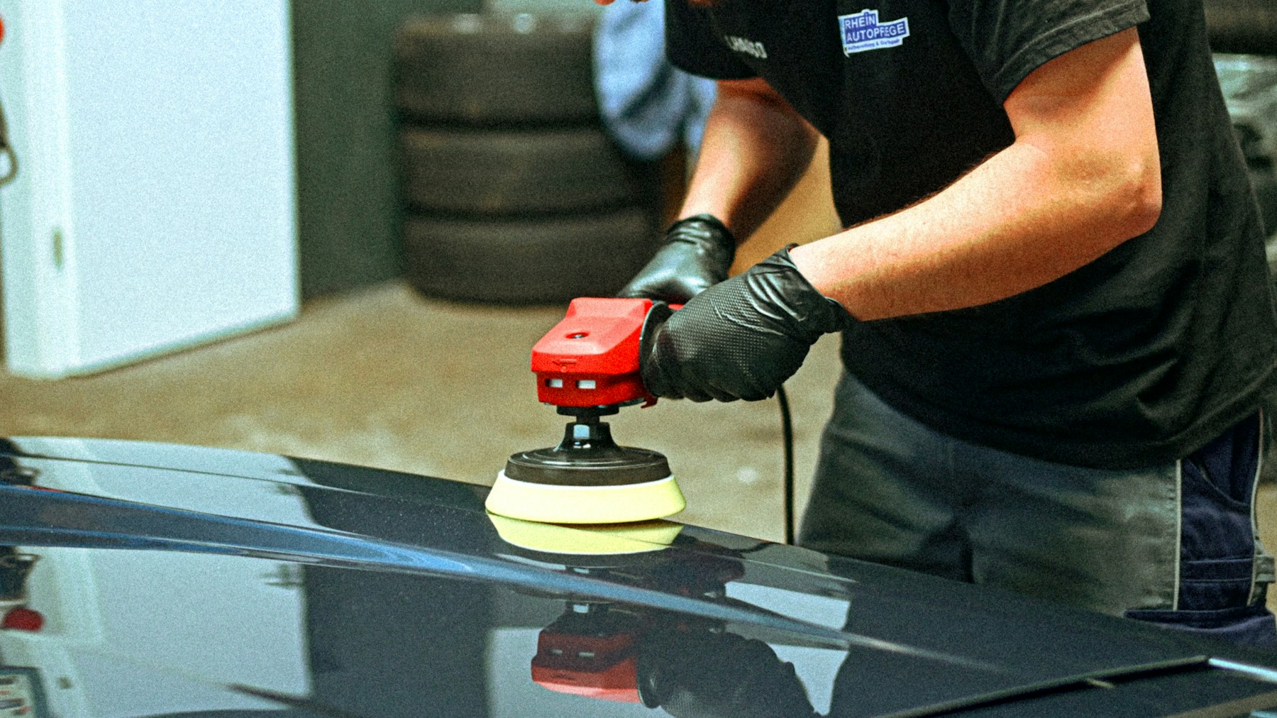 Technician polishing vehicle in a professional studio